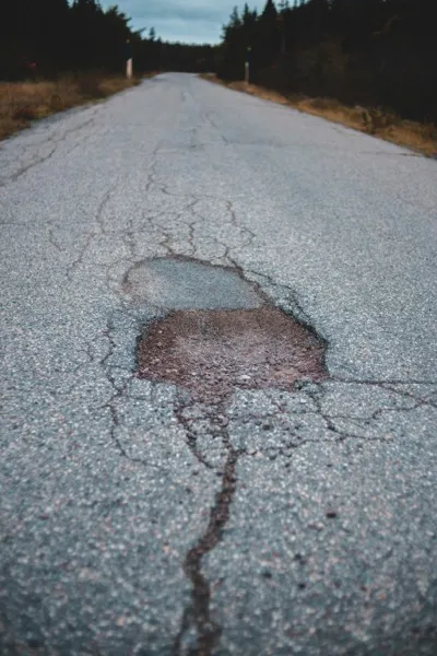 Road surface with visible cracks and pavement defects requiring condition assessment